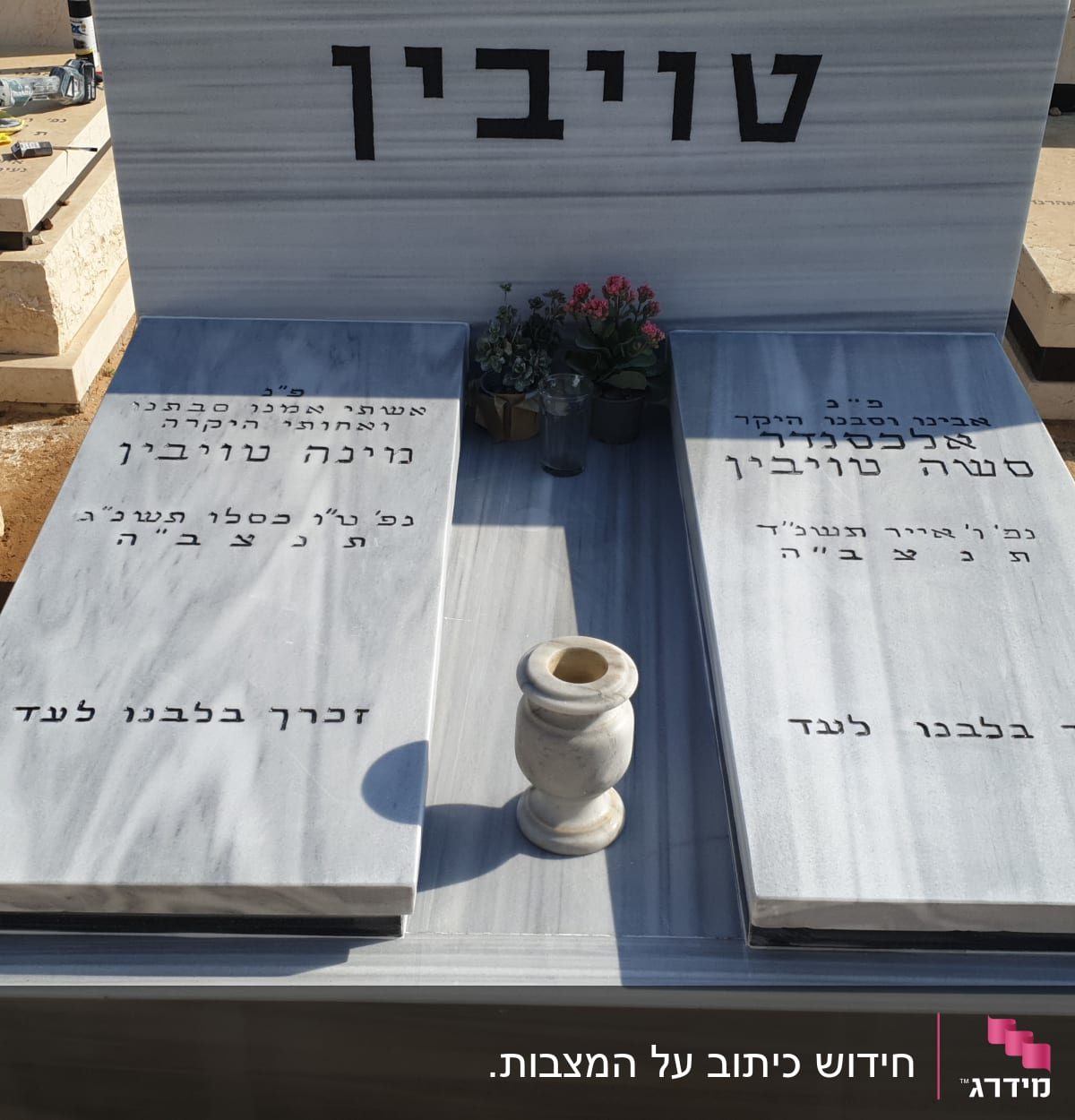 שני מצבות שיש עם כיתוב בעברית ועציץ ביניהן